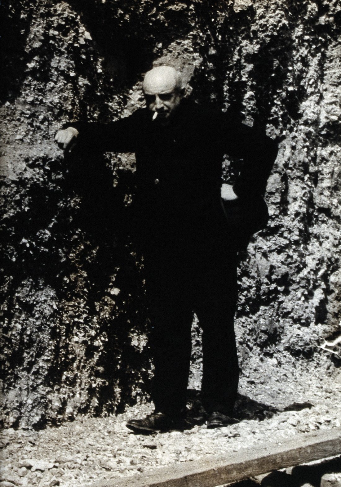 L'abbé Henri Breuil au pied d'une paroi rocheuse