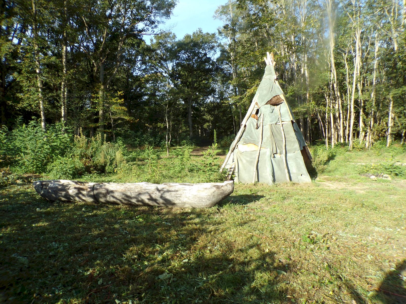 Tente conique en peaux et pirogue monoxyle