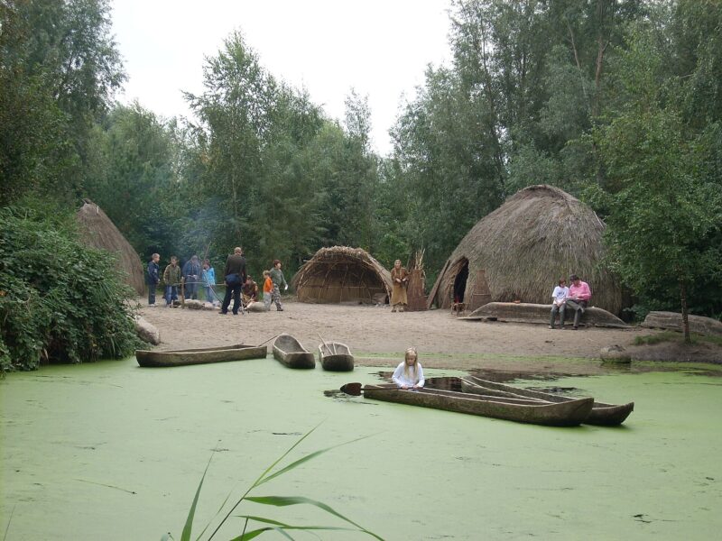 Campement préhistorique reconstitué au bord d’un plan d’eau