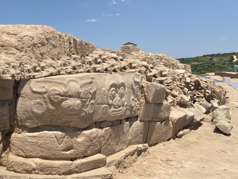 Mur de pierre de la cité de Shimao, orné de frises sculptées de visages et d’animaux.