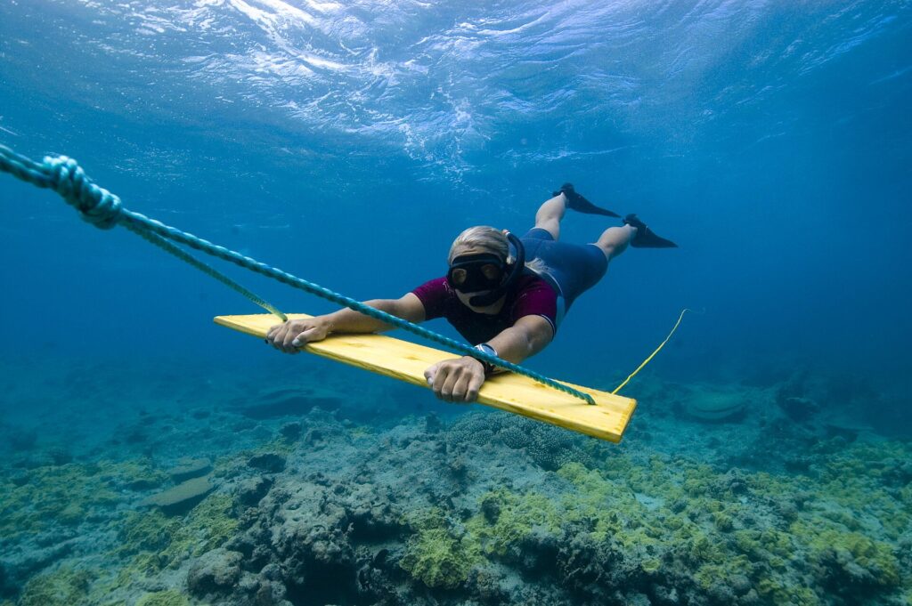 Archéologue plongeur tracté sous l’eau au-dessus d’un fond marin lors d’une prospection