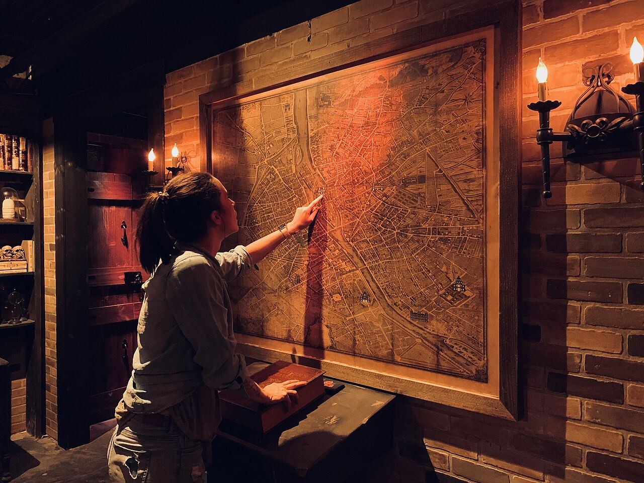 Joueuse examinant une carte ancienne dans une salle d’escape game