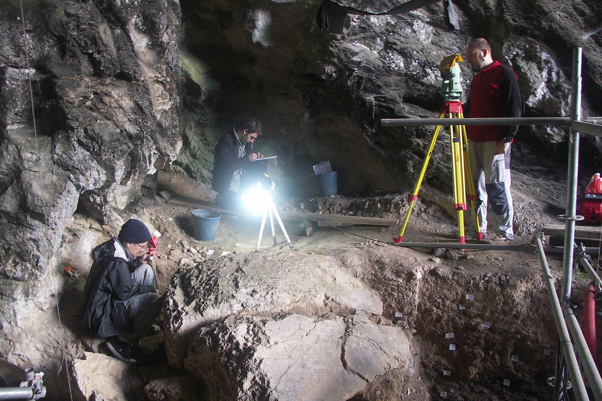 Archéologues fouillant la grotte d’El Mirón, en Cantabrie, près du grand bloc calcaire