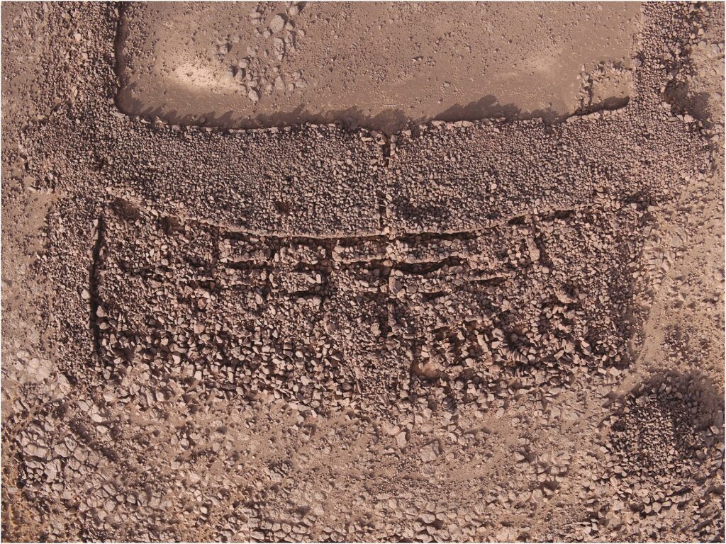 Vue aérienne des rangées de plates-formes et de tunnels devant la base d’un mustatil
